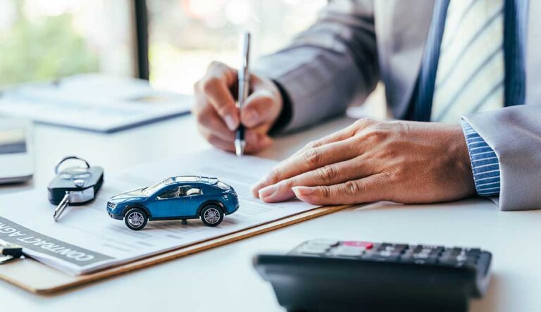 Driver reviews a car loan statement and auto insurance documents beside a parked vehicle.